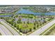Aerial view of the neighborhood with mature trees, community pool, tennis court, and waterfront homes at 9860 Smarty Jones Dr, Ruskin, FL 33573