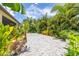Beautifully landscaped backyard with lush plants and a paved area to enjoy outdoor living at 9860 Smarty Jones Dr, Ruskin, FL 33573