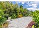 Spacious paved backyard area bordered by lush tropical landscaping for privacy and beauty at 9860 Smarty Jones Dr, Ruskin, FL 33573