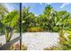 Professionally landscaped backyard featuring lush tropical foliage and a paved area at 9860 Smarty Jones Dr, Ruskin, FL 33573