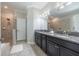 Well-lit bathroom with dual sinks, granite countertops, tiled floor and glass-door shower at 9860 Smarty Jones Dr, Ruskin, FL 33573
