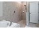 Bathroom with a walk-in shower with gray tiling and a white soaking tub at 9860 Smarty Jones Dr, Ruskin, FL 33573