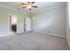 Spacious bedroom featuring a ceiling fan and view to an attached bathroom and walk-in closet at 9860 Smarty Jones Dr, Ruskin, FL 33573