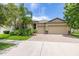 Beautiful home featuring a manicured lawn and a two-car garage with brick-paved driveway, adding to its curb appeal at 9860 Smarty Jones Dr, Ruskin, FL 33573