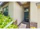 Inviting entryway with a dark green front door, decorative stone accents, and lush green ferns at 9860 Smarty Jones Dr, Ruskin, FL 33573
