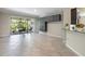 Bright living room showcasing neutral decor, tile flooring, and seamless access to the screened-in lanai at 9860 Smarty Jones Dr, Ruskin, FL 33573