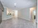 Spacious living room showing the tile floors, neutral paint, and open floor plan with the kitchen in the background at 9860 Smarty Jones Dr, Ruskin, FL 33573