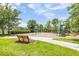 Neighborhood playground with slides, swings, lush landscaping, and seating for the residents to enjoy at 9860 Smarty Jones Dr, Ruskin, FL 33573