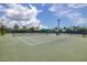 Well maintained tennis court, covered seating, mature landscaping, and views of the lake in the community at 9860 Smarty Jones Dr, Ruskin, FL 33573