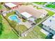 Aerial view of the fenced backyard featuring a sparkling pool, patio area, and mature landscaping at 11082 90Th Ter, Seminole, FL 33772