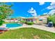 Backyard view featuring a pool, patio, well-manicured lawn and the exterior of the home at 11082 90Th Ter, Seminole, FL 33772