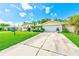 Well-maintained single-story home featuring a front yard with a manicured lawn and a paved driveway at 11082 90Th Ter, Seminole, FL 33772