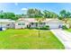 Charming single-story home with a manicured lawn, lush greenery, and an inviting facade at 11082 90Th Ter, Seminole, FL 33772