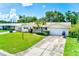 Front exterior of a one-story home with a well-manicured lawn, paved driveway, and American flag at 11082 90Th Ter, Seminole, FL 33772