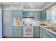 Kitchen features blue cabinets, white appliances, and plenty of storage space at 11082 90Th Ter, Seminole, FL 33772