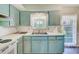 The Kitchen boasts blue cabinetry and a double sink with a window view at 11082 90Th Ter, Seminole, FL 33772