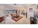 Spacious living room with tile flooring, ceiling fans, and sliding glass doors to the lanai at 11082 90Th Ter, Seminole, FL 33772