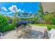 Outdoor patio with dining furniture, grill and umbrella in a lush, landscaped backyard at 11082 90Th Ter, Seminole, FL 33772