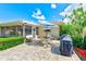 Paved patio area with outdoor seating and a grill, perfect for entertaining in a backyard setting at 11082 90Th Ter, Seminole, FL 33772