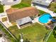 Aerial view of backyard featuring a sparkling pool, lawn, patio area, and privacy fencing at 11398 88Th Ave, Seminole, FL 33772