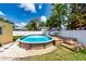 An above ground pool sits in a landscaped backyard with mature trees at 11398 88Th Ave, Seminole, FL 33772