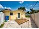 Backyard with wooden patio, blue door, gravel, white fence, and blue recycle bin at 11398 88Th Ave, Seminole, FL 33772