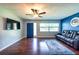 Spacious living room featuring hardwood floors, a blue accent wall, and an open layout at 11398 88Th Ave, Seminole, FL 33772