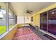 Relaxing enclosed patio with ceiling fan, colorful rug and sliding glass doors at 11398 88Th Ave, Seminole, FL 33772