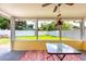 Enclosed patio featuring a ceiling fan, vibrant rug, and glass table with view of backyard at 11398 88Th Ave, Seminole, FL 33772