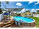 Backyard with an above ground pool, wooden deck, umbrella, lounge chairs, and privacy fence at 11398 88Th Ave, Seminole, FL 33772