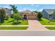 A beautiful single story home with a well-manicured lawn and brick-paved driveway in a quiet neighborhood at 1242 Windy Bay Shl, Tarpon Springs, FL 34689