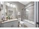 Well-lit bathroom features a shower-tub combo with sliding glass doors and a modern vanity at 1242 Windy Bay Shl, Tarpon Springs, FL 34689