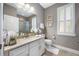 Bright bathroom boasts a large vanity, shuttered window, and a shower over the toilet at 1242 Windy Bay Shl, Tarpon Springs, FL 34689