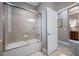 Modern bathroom with a shower-tub featuring tiled walls, glass doors, and chrome fixtures at 1242 Windy Bay Shl, Tarpon Springs, FL 34689