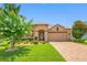 Charming single-story home with a well-manicured lawn, colorful landscaping, and a brick-paved driveway at 1242 Windy Bay Shl, Tarpon Springs, FL 34689
