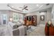 Cozy living room featuring a ceiling fan, tray ceilings, and a neutral color scheme at 1242 Windy Bay Shl, Tarpon Springs, FL 34689