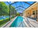 Long pool featuring a screened-in enclosure, outdoor seating, and a view of the lake at 1242 Windy Bay Shl, Tarpon Springs, FL 34689