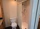 Bright bathroom featuring a glass shower, toilet and wooden cabinetry with a granite countertop at 1281 Pine Ridge E Cir # B1, Tarpon Springs, FL 34688