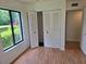 Bedroom with bi-fold closet doors, a window with lake view, and vinyl flooring at 1281 Pine Ridge E Cir # B1, Tarpon Springs, FL 34688