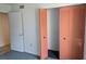 Bedroom closet with salmon bi-fold doors slightly open, next to a white door at 1281 Pine Ridge E Cir # B1, Tarpon Springs, FL 34688