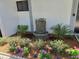 Charming front yard with a decorative fountain and vibrant flower beds at 1281 Pine Ridge E Cir # B1, Tarpon Springs, FL 34688