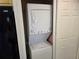 Laundry area featuring a stacked washer and dryer, with a glimpse of a black refrigerator at 1281 Pine Ridge E Cir # B1, Tarpon Springs, FL 34688