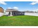 Wide view of a spacious backyard featuring a screened lanai and white picket fence at 12835 Wildflower Meadow Dr, Riverview, FL 33579