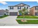 Two-story home with a well-manicured lawn, grey paint, black shutters, and a two-car garage at 12835 Wildflower Meadow Dr, Riverview, FL 33579