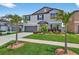 Two-story home with a well-manicured lawn, palm trees, and a two-car garage at 12835 Wildflower Meadow Dr, Riverview, FL 33579