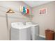 Functional laundry room with modern washer and dryer, plus convenient shelving for storage at 12835 Wildflower Meadow Dr, Riverview, FL 33579