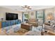 Cozy living room featuring comfortable seating, a large television, and natural light at 12835 Wildflower Meadow Dr, Riverview, FL 33579