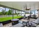 Covered patio area with comfortable seating, ceiling fan, fire pit, and view of a fenced yard at 12835 Wildflower Meadow Dr, Riverview, FL 33579