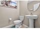 Elegant powder room featuring a pedestal sink, round mirror, and toilet at 12835 Wildflower Meadow Dr, Riverview, FL 33579