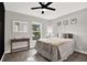 Well-lit bedroom with a comfortable bed, stylish decor, and wood-look flooring at 13111 Fruitville Way, Riverview, FL 33579